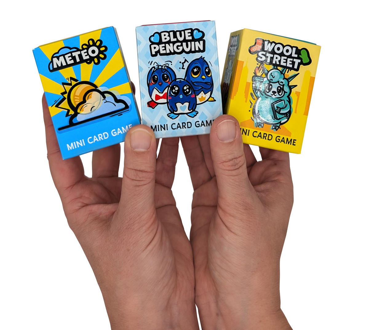 Mini-Pinguin-Kartenspiel in der Hand, drei Schachteln nebeneinander