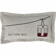 Graues Traumkissen mit Spruch „AUF DEM WEG…“ und roter Straßenbahn-Grafik