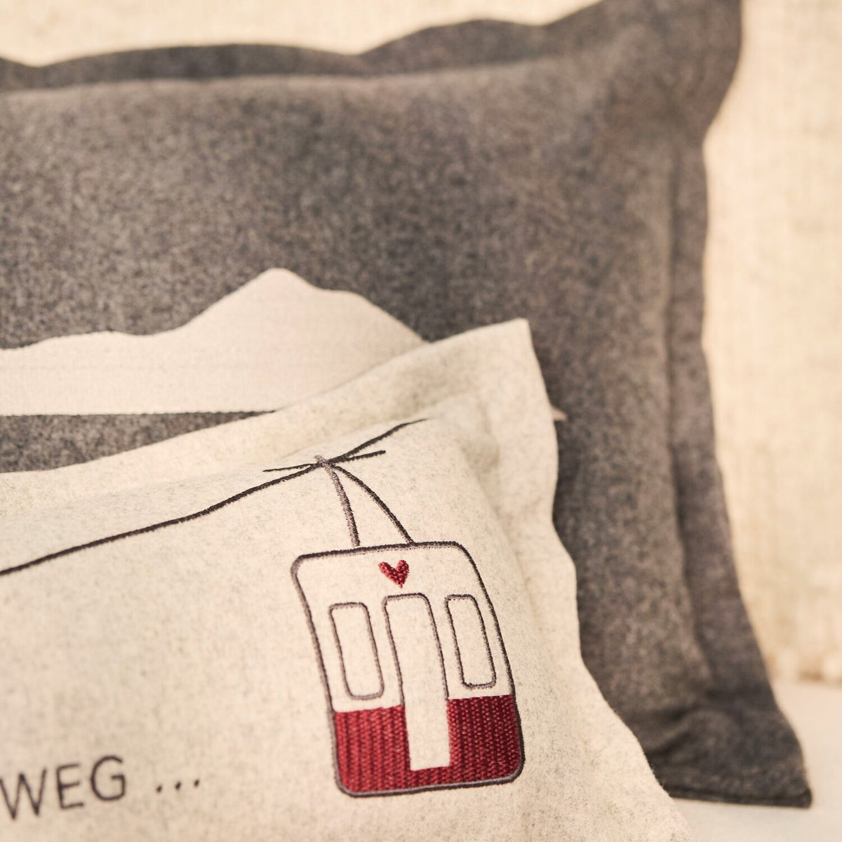 Detail: beiges Traumkissen mit Straßenbahn-Icon und roter Unterkante