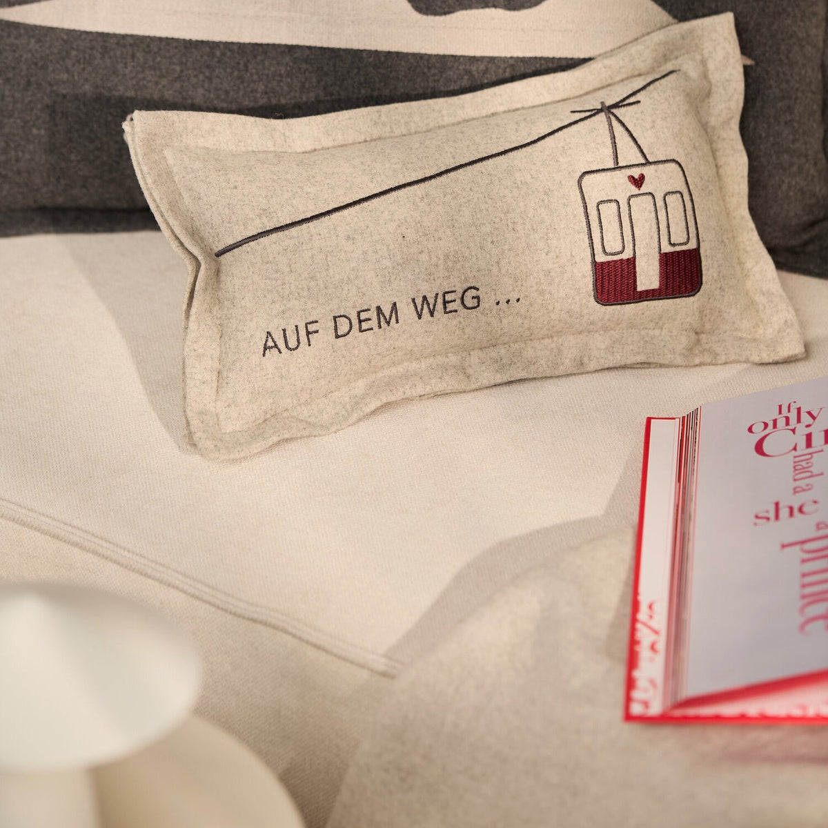 Helles Traumkissen mit Spruch „AUF DEM WEG…“ und Straßenbahn-Icon