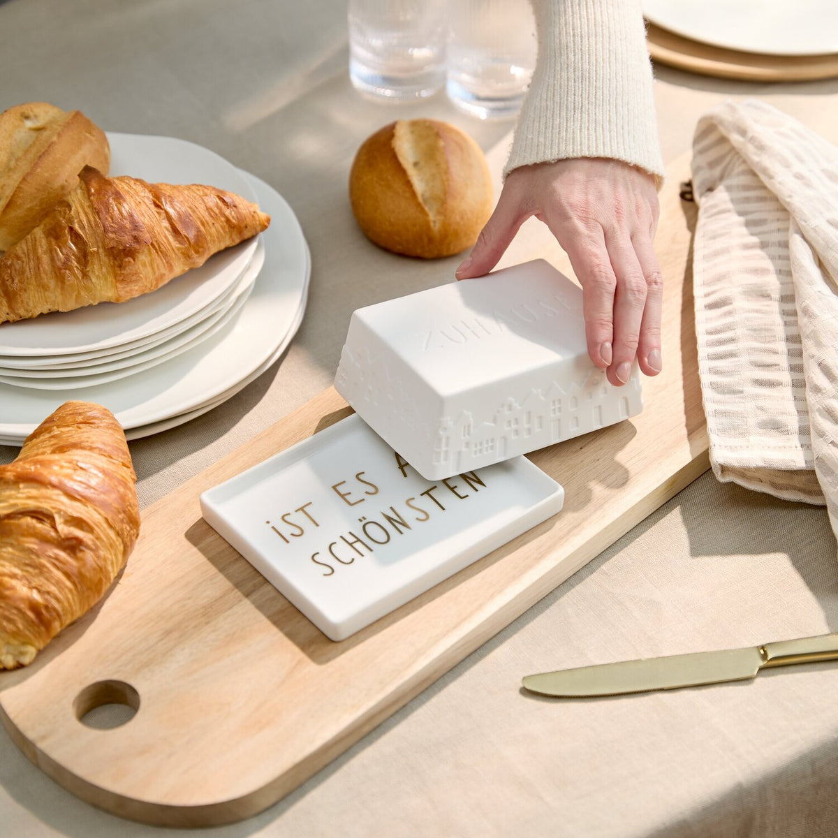 Weiße Butterdose auf Holzbrett, offene Box mit „IST ES AM SCHÖNSTEN“