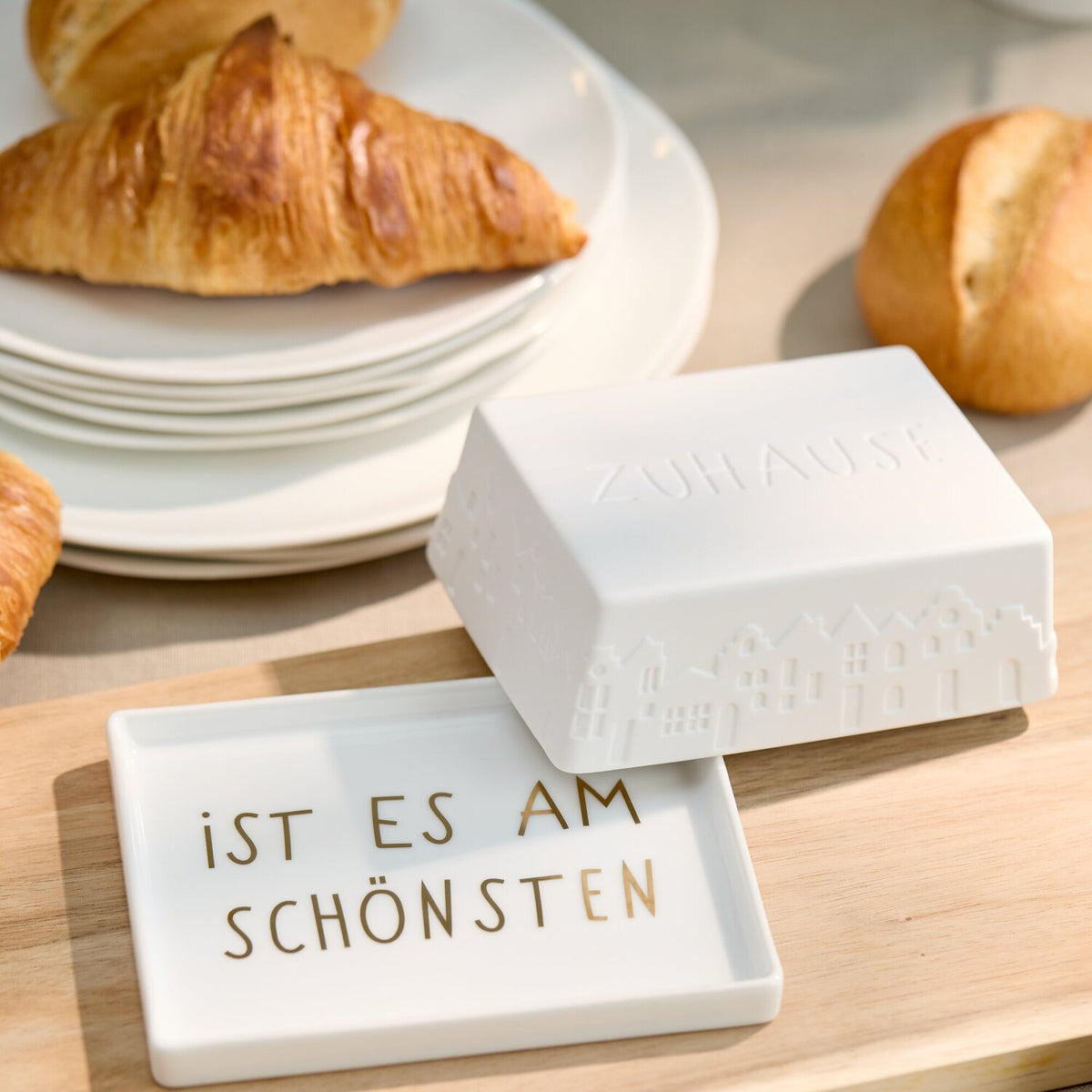 Weiße Butterdose mit „IST ES AM SCHÖNSTEN“-Aufschrift und geprägtem Stadtmotiv