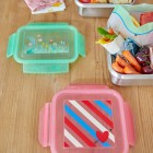 Lunchbox mit rosa Deckel und blau-rot-weißen Streifen, von oben