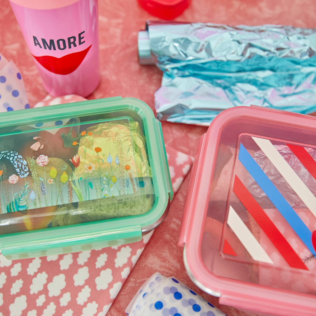 Rosa Lunchbox mit Streifen-Design und Herz, geöffnet mit Inhalt