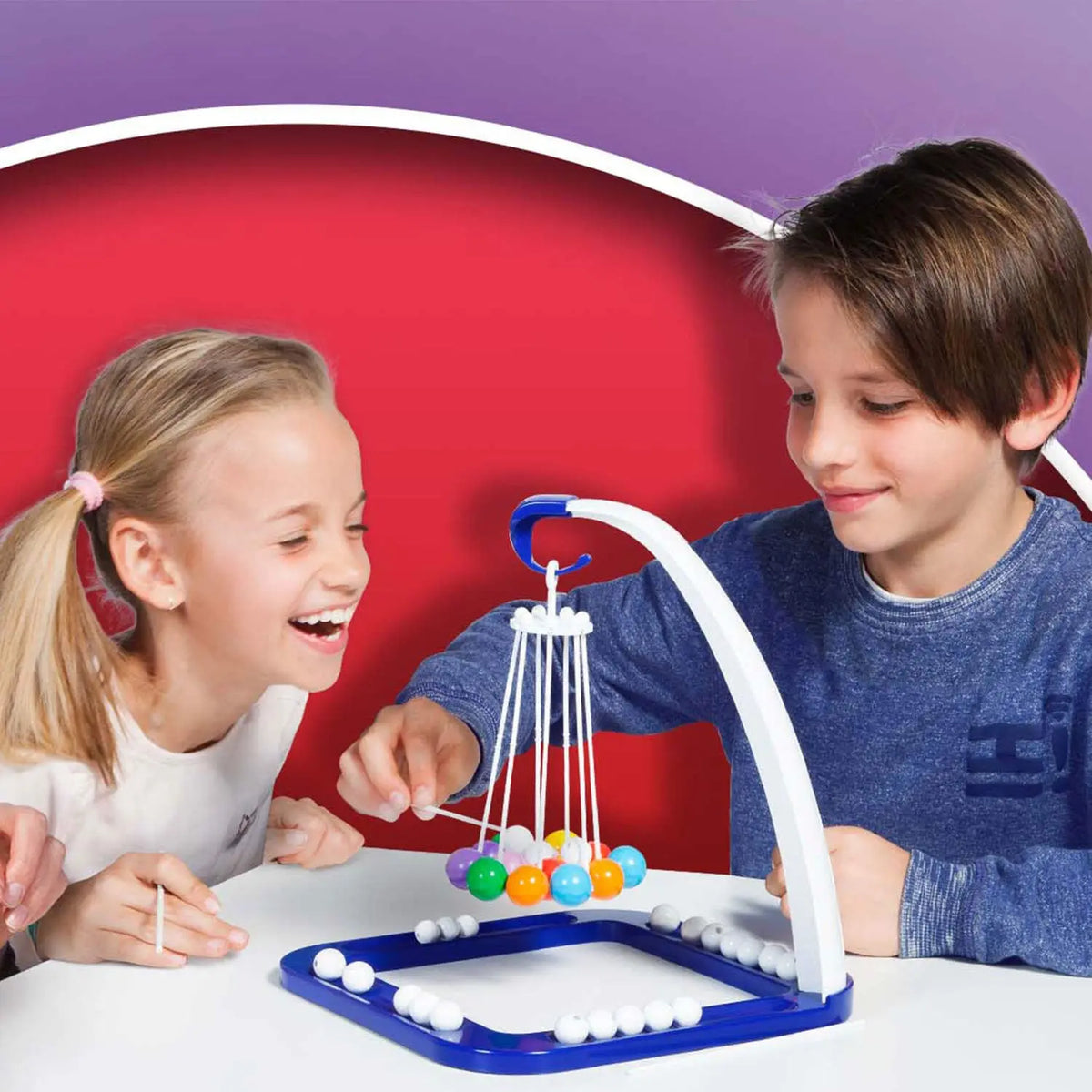 Balla Balla Kugelspiel: Kinder am Tisch mit weiß-blauer Kugel-Aufhängung und bunten Kugeln