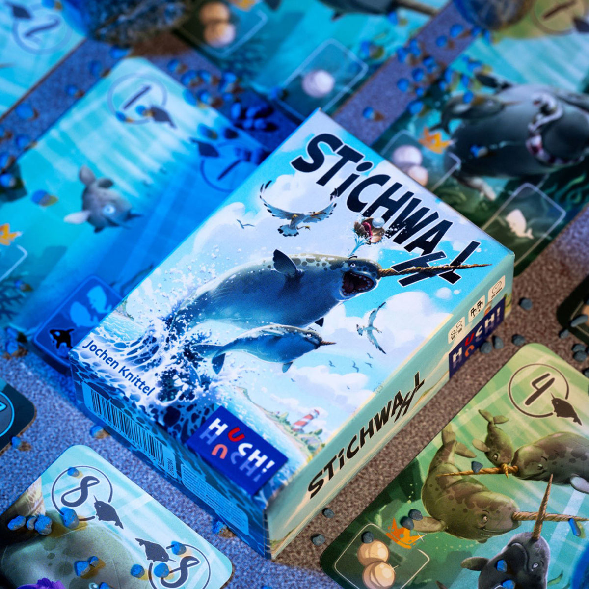 Brettspiel-Box mit Walen und farbigen Spielkarten-Elementen