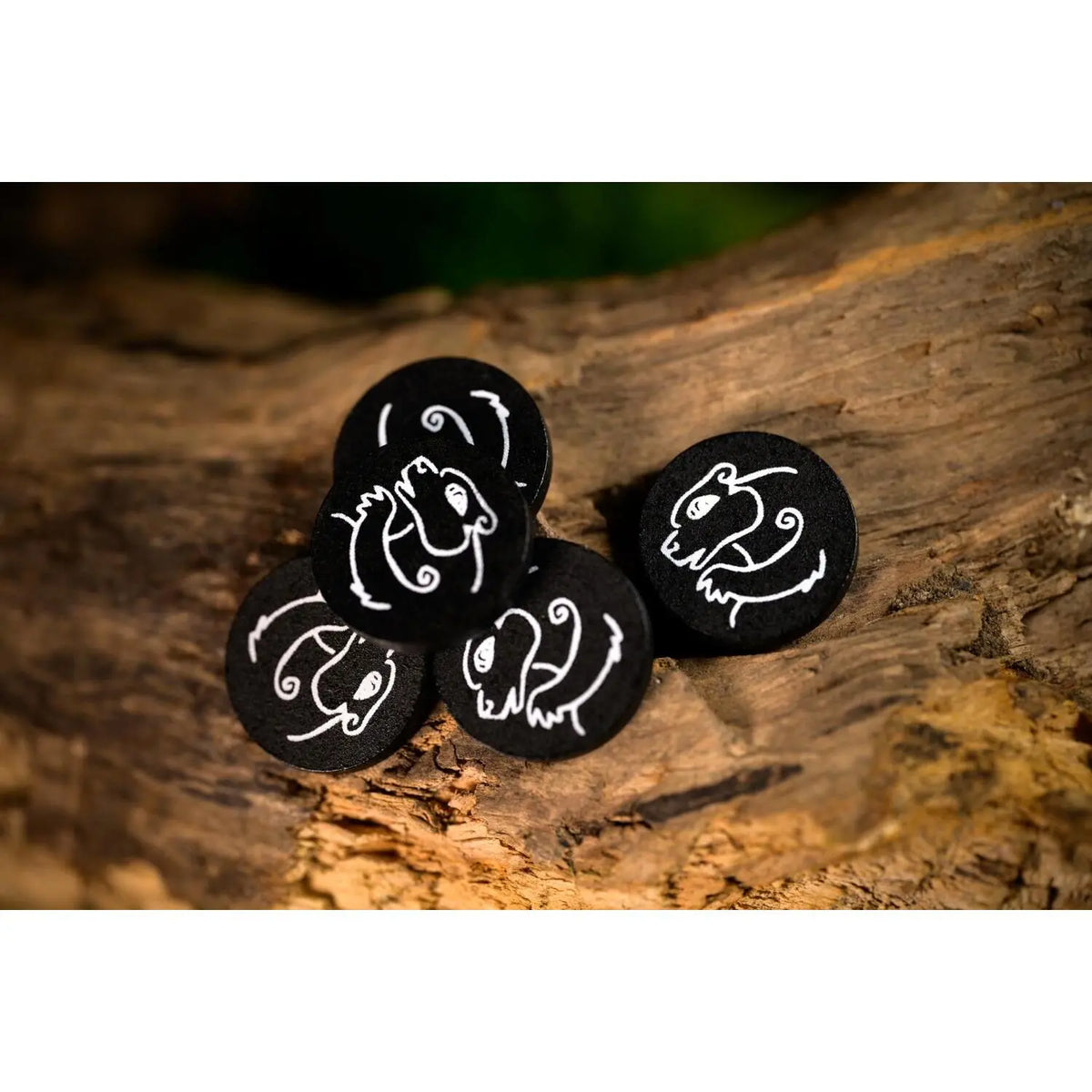 Drei schwarze Spielmarker mit weißen Tier-Symbolen