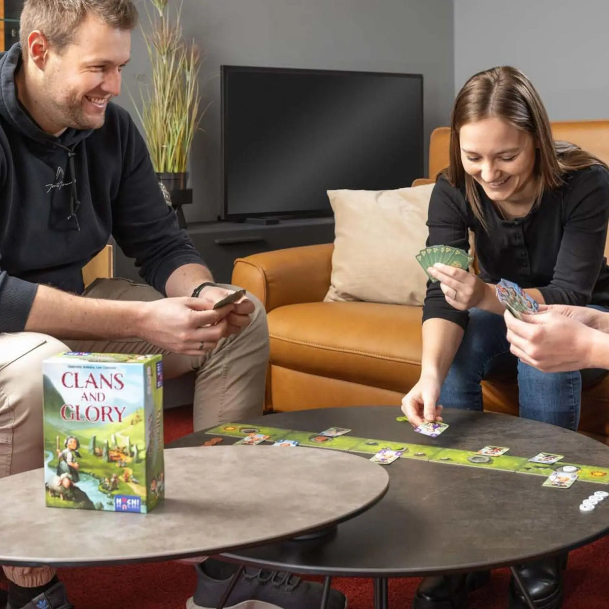 „Clans and Glory“ Brettspiel-Box mit Spielkarten auf dem Tisch