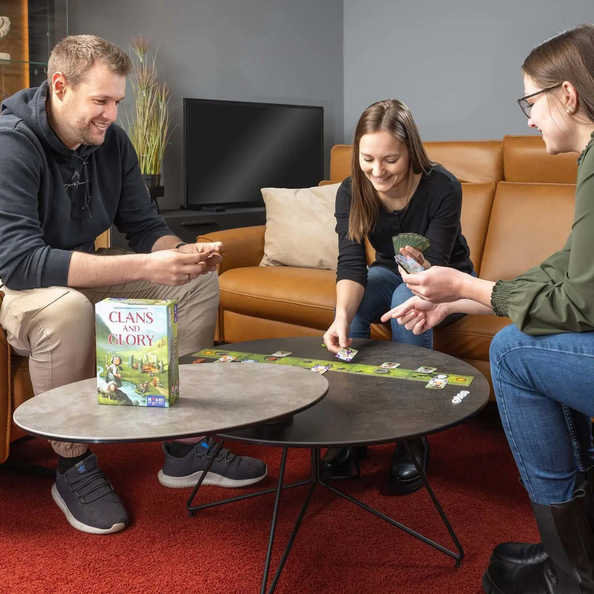 „Clans and Glory“ Brettspiel-Box mit Spielkarten auf dem Tisch