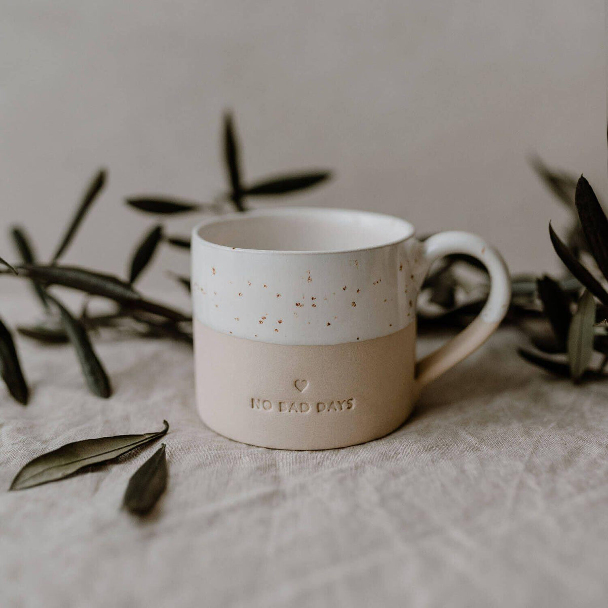 Tasse „No Bad Days“ naturfarben mit Sprenkel-Design, Schrift auf der Vorderseite, Henkel
