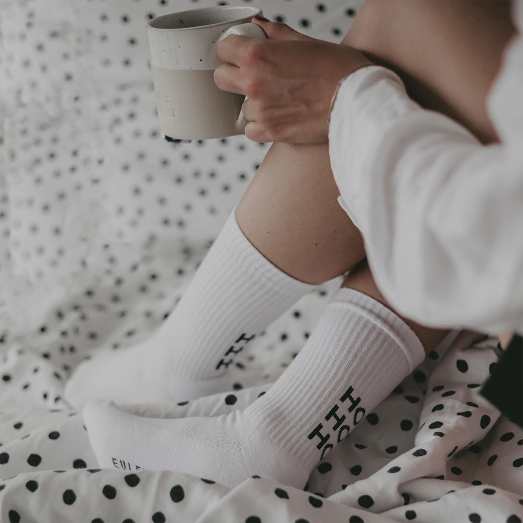 Weiße Socken mit „HO HO HO“-Print, im sitzenden Lagenbild