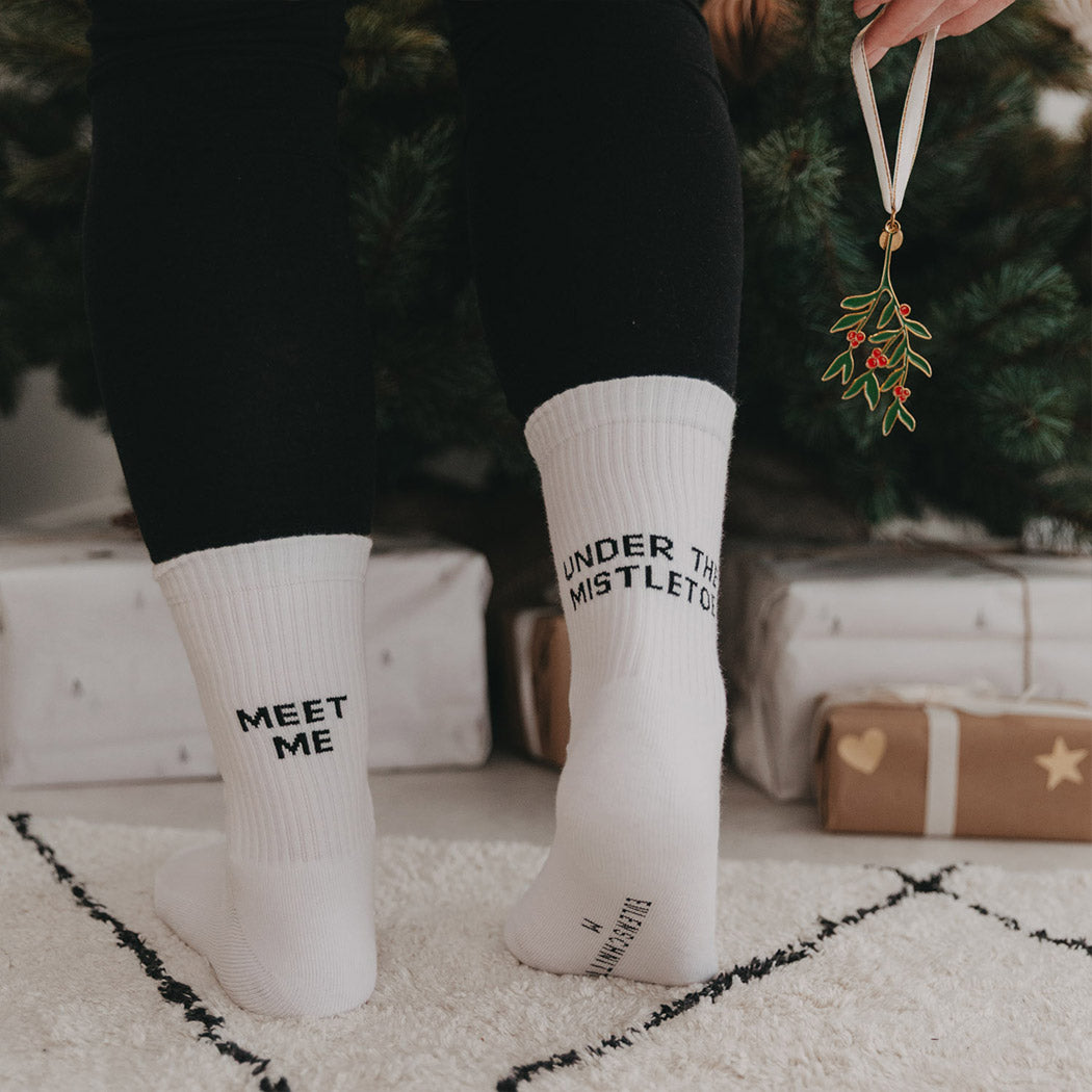 Weiße Socken am Fuß, „MEET ME“ und „UNDER THE MISTLETOE“