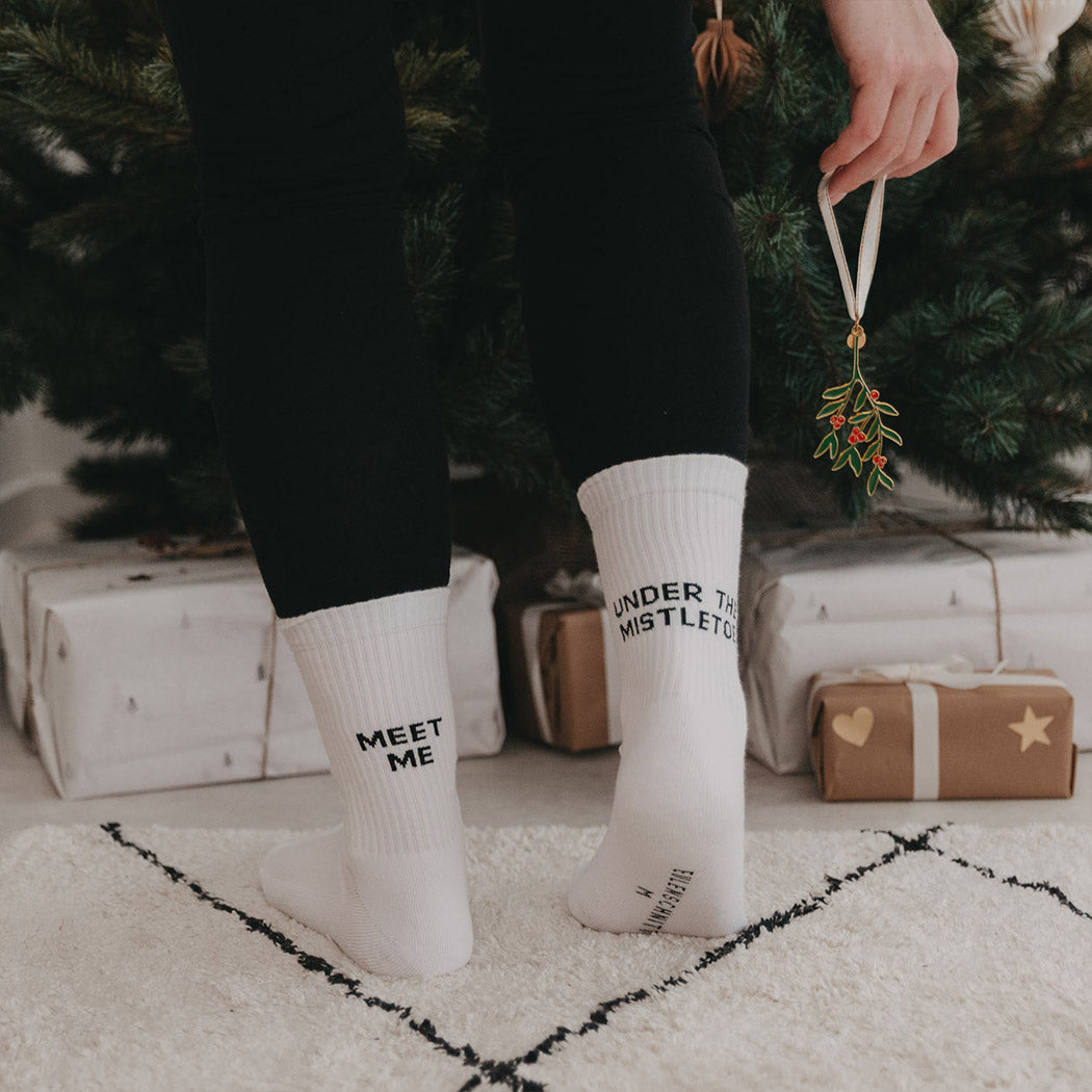 Weiße Socken am Fuß, „MEET ME“ und „UNDER THE MISTLETOE“