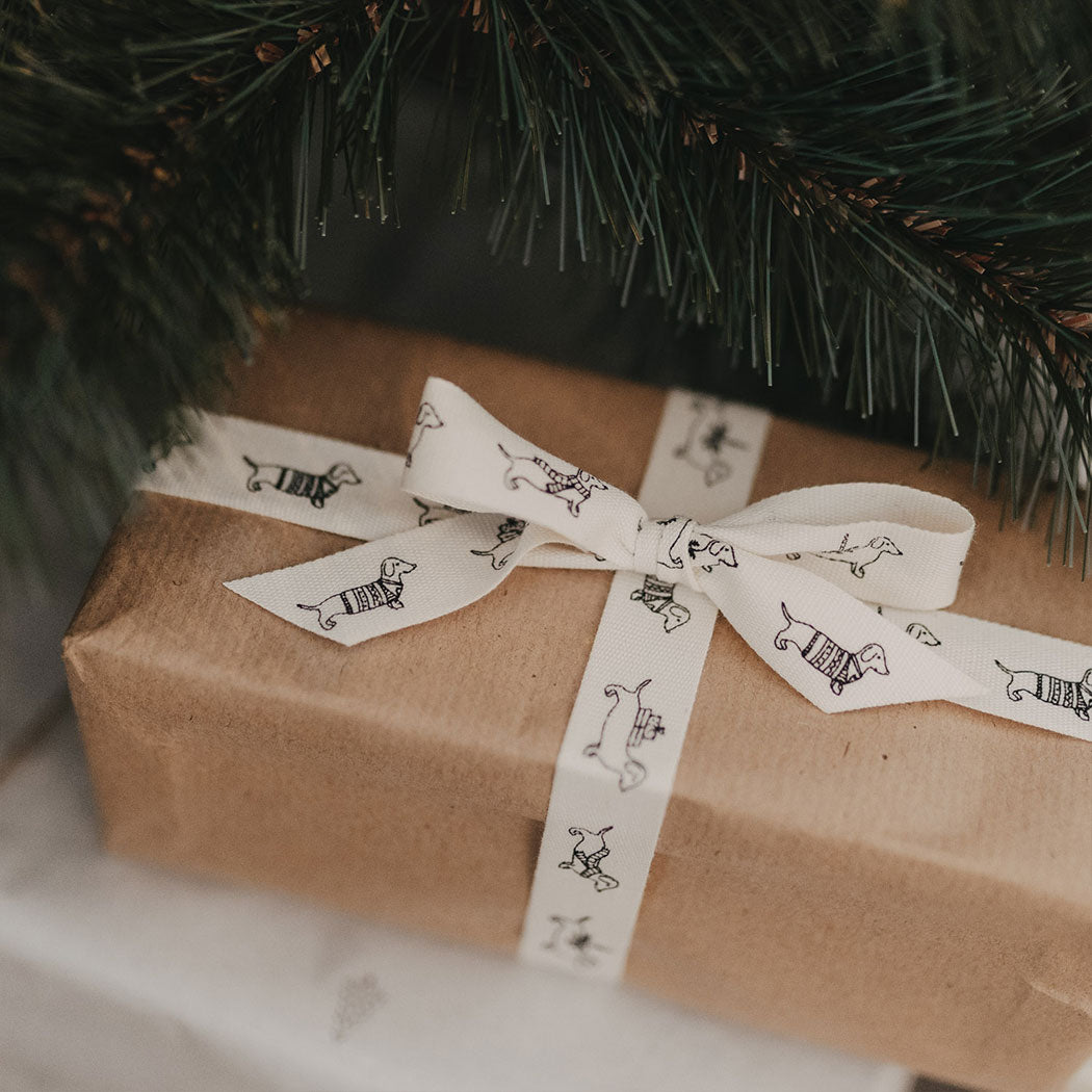 Geschenkband mit Dackelprint als Schleife auf Geschenkband, naturfarben, schwarz bedruckt