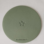 Grüne Untersetzer mit Stern-Prägung, rund, aus Kunstleder; Sicht auf Logo unten.