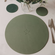 Grünes, rundes Platzset aus Kunstleder mit eingestelltem Sternmotiv in der Mitte