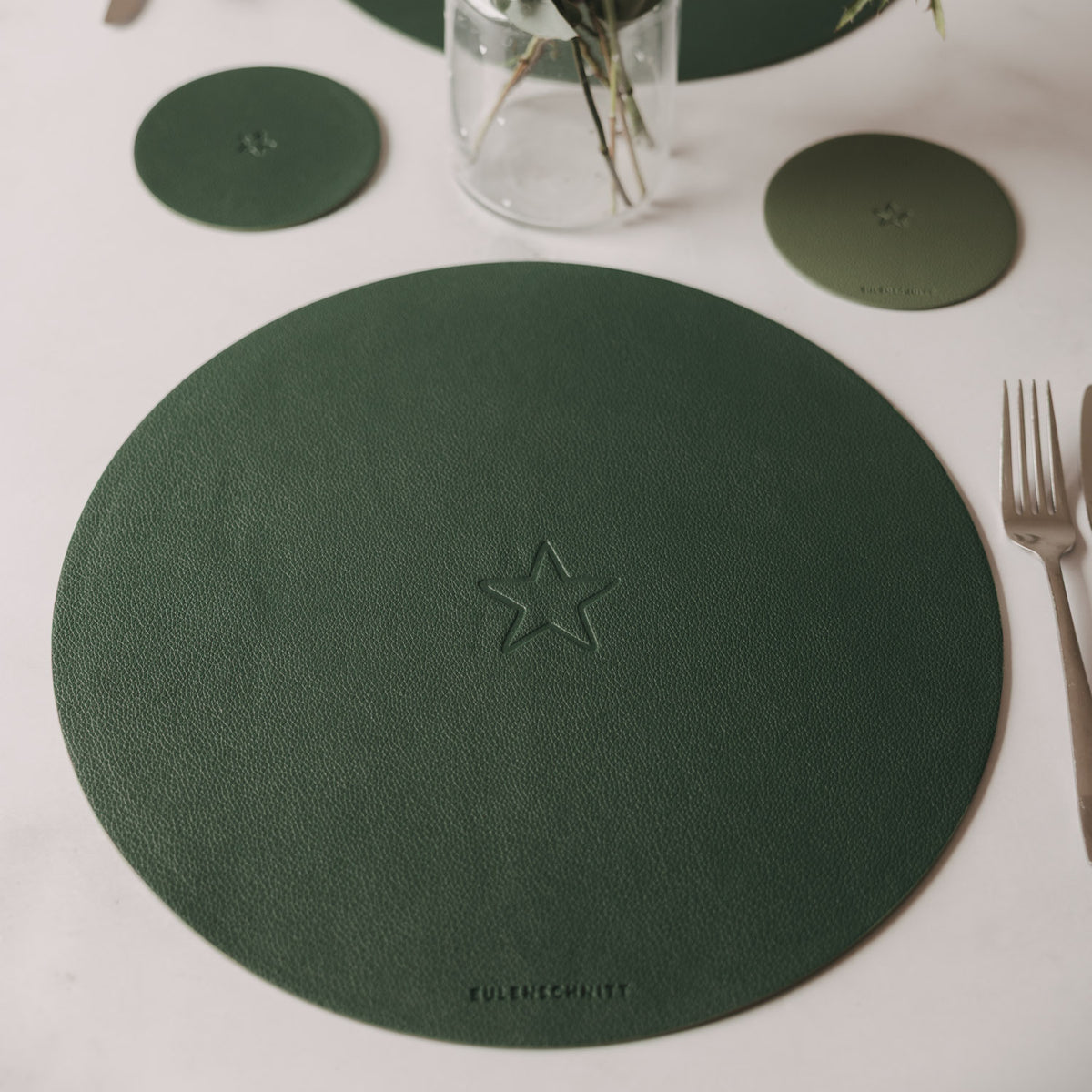 Grünes Platzset rund mit Stern-Prägung in der Mitte, dekoratives Tisch-Setup