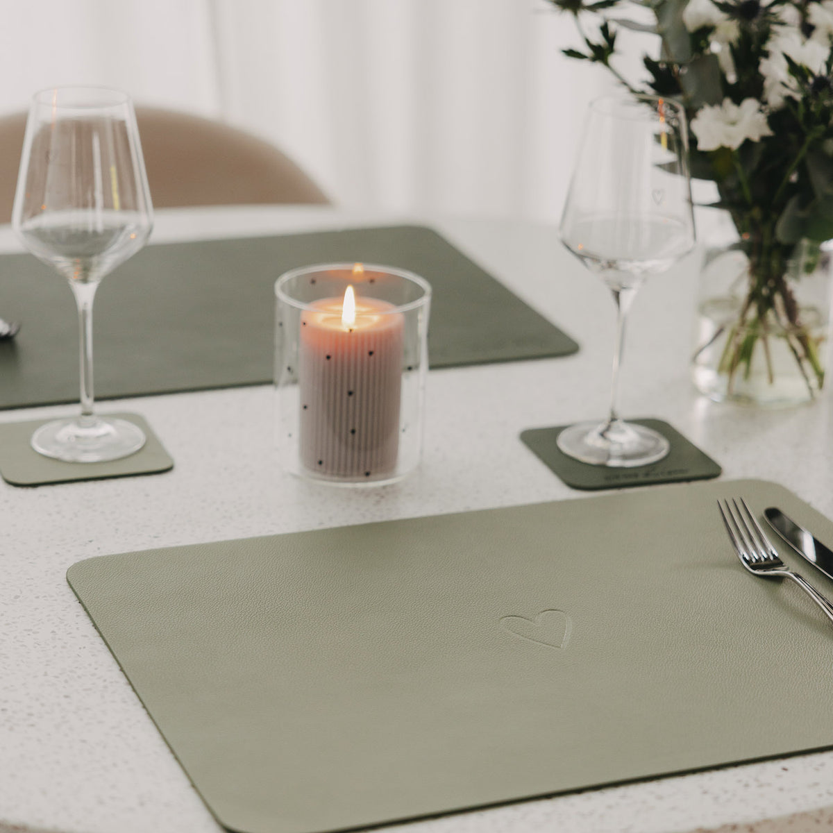 Grünes Platzset mit Herz-Prägung auf dem Tisch, rechteckig
