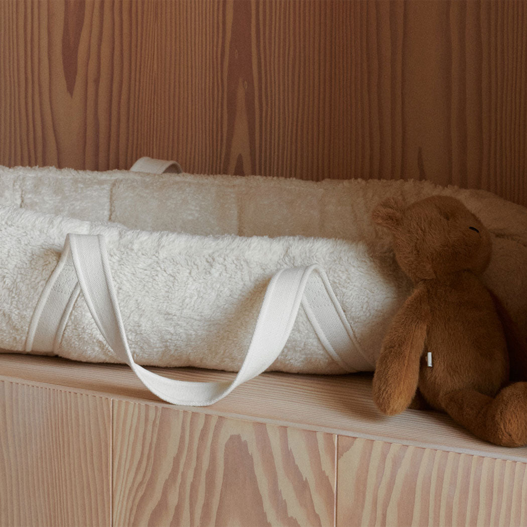 Tragbares Babynest Gro Pile (Sandy) mit Tragriemen auf Liegefläche, mit Kuscheltier