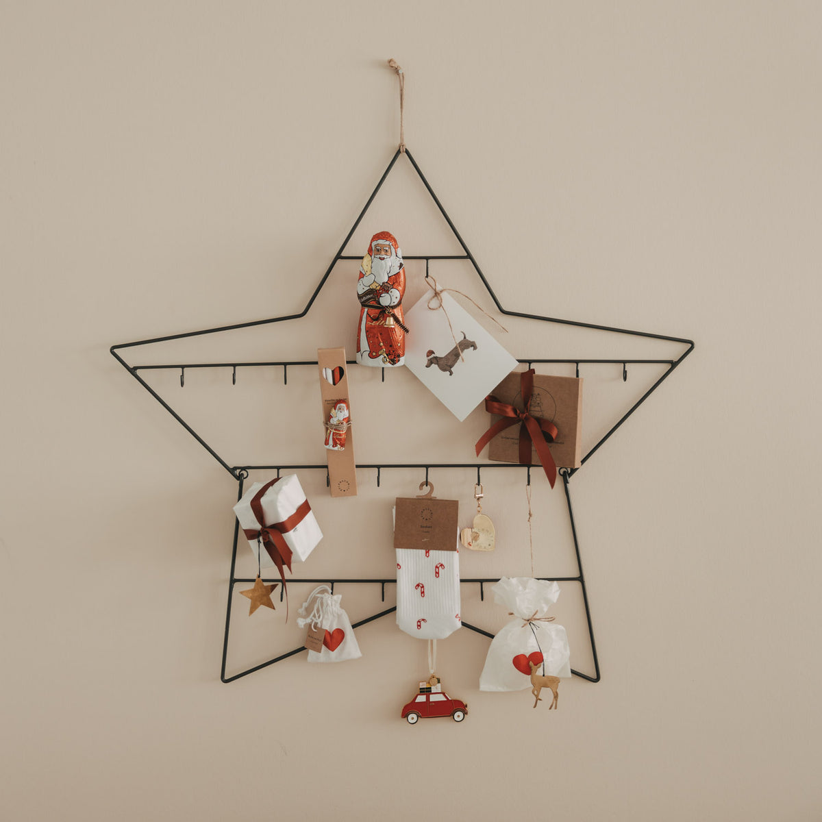 Großer Adventskalender Stern mit Geschenkanhängern, Holzfiguren und Schleifen am Rahmen
