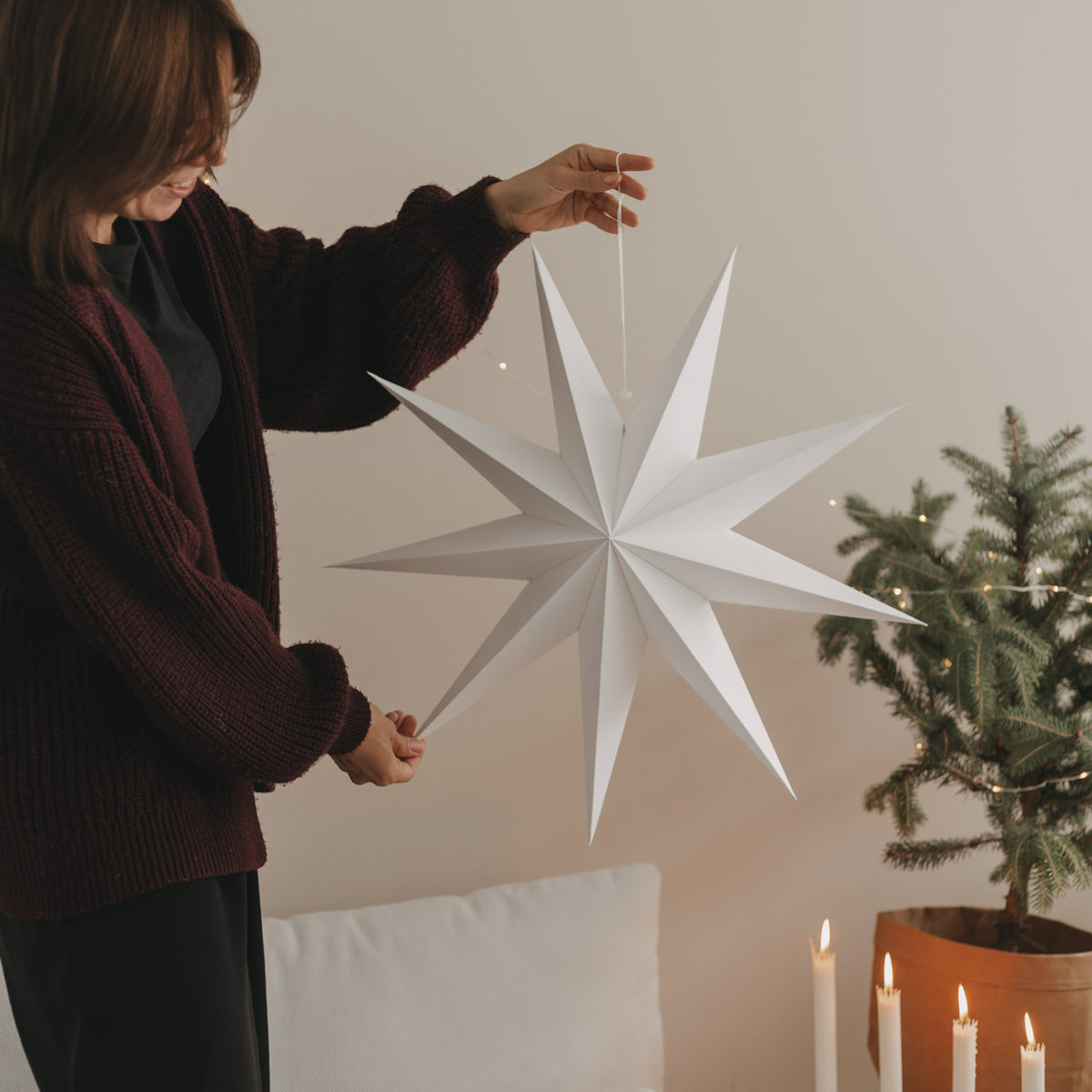 Weißer Papierstern an Aufhängeschnur, wird an der Decke befestigt