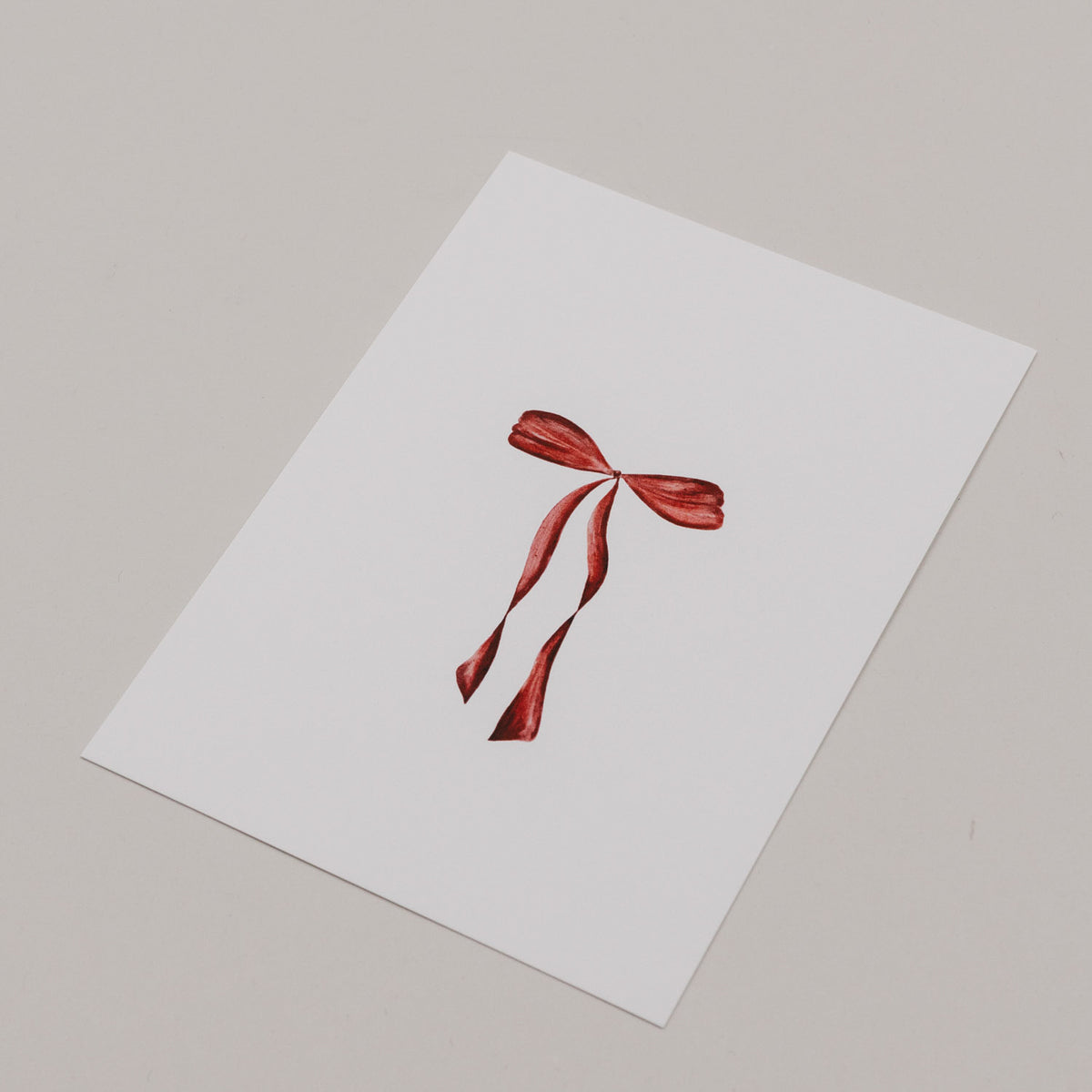 Aquarellkarte mit roter Schleife, Vorderseite im Schrägblick
