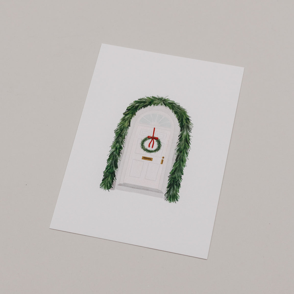 Aquarellkarte mit Türmotiv und grünem Tannenzweigen-Kranz, rotem Ornament