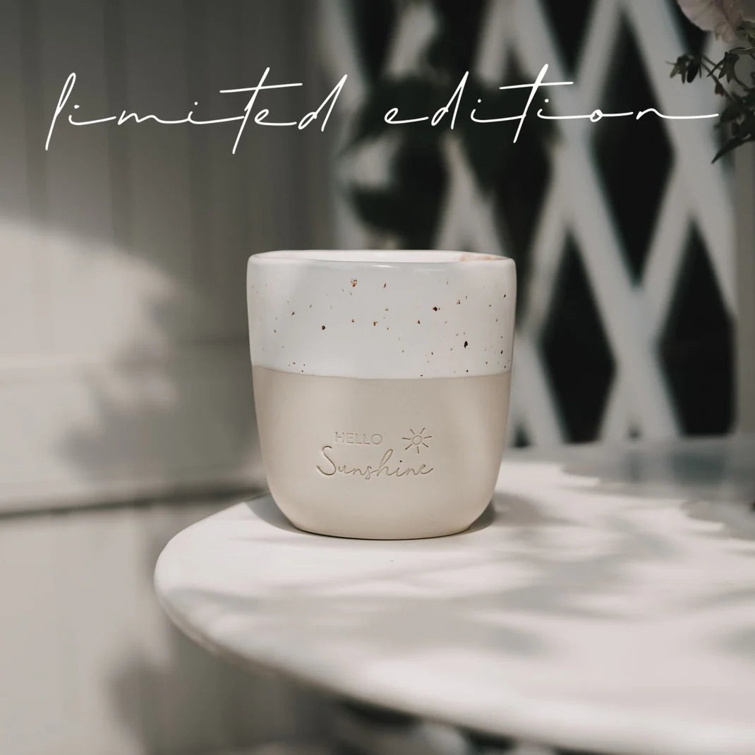 Naturfarbener Becher mit „Hello Sunshine“-Aufdruck und Sprenkeln auf Tisch