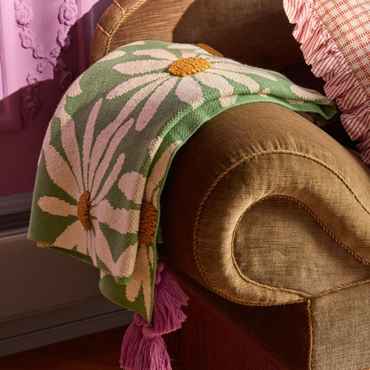 Drapierte Decke mit großen Blumen in Grün/Creme, gelben Zentren und lila Quasten