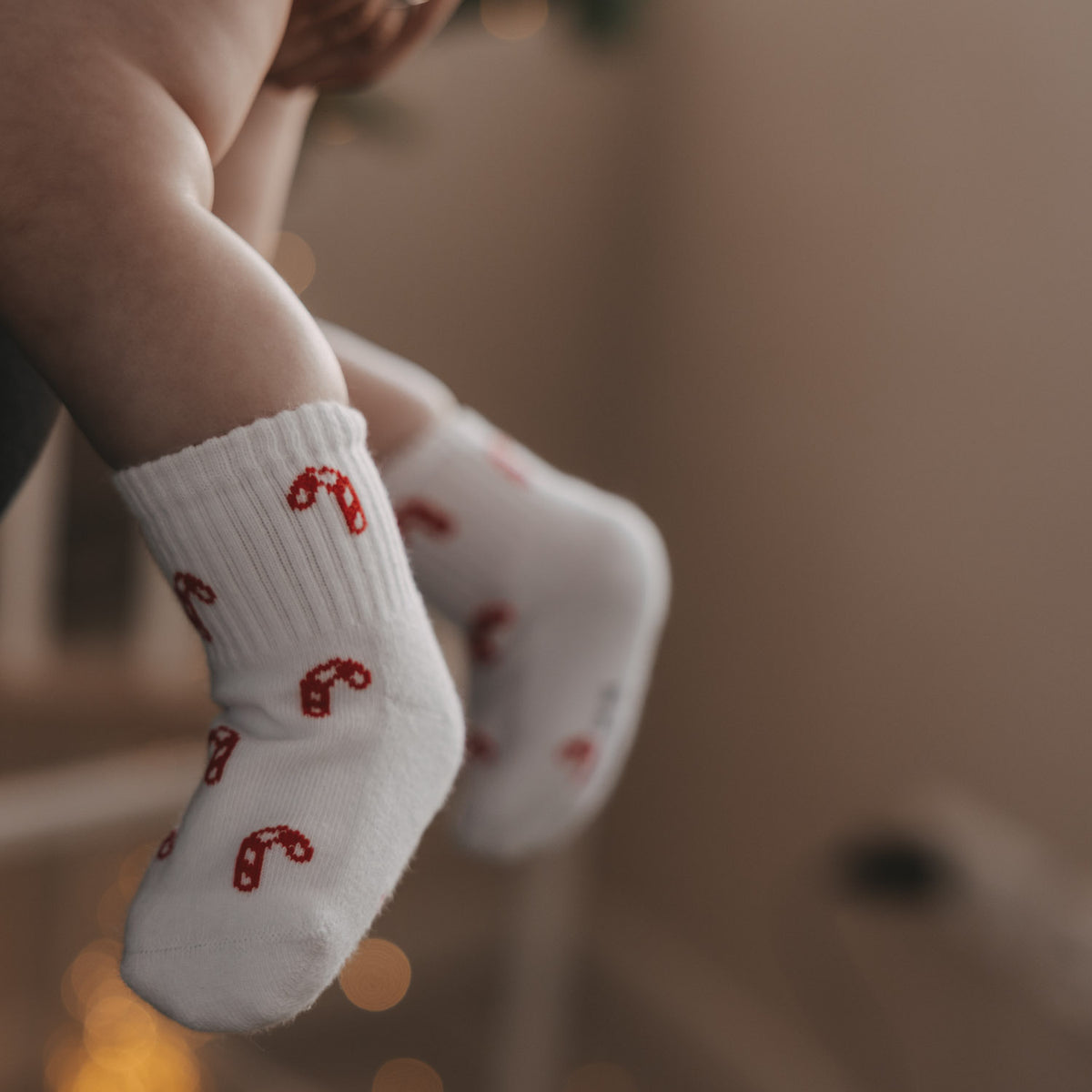 Babysocken in Weiß mit rotem Zuckerstangenmuster, Fussbereich im Nahblick