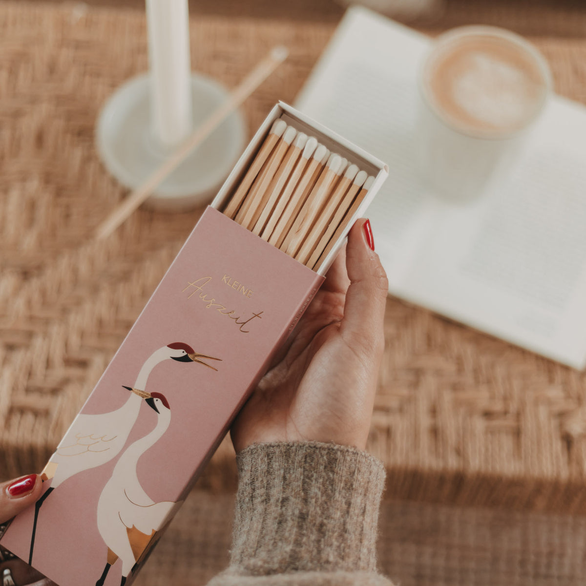 Geöffnete rosa Streichhölzer-Box mit Kranich-Motiv und sichtbaren Zündhölzern